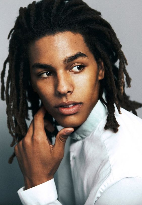 a man with dreadlocks wearing a white shirt