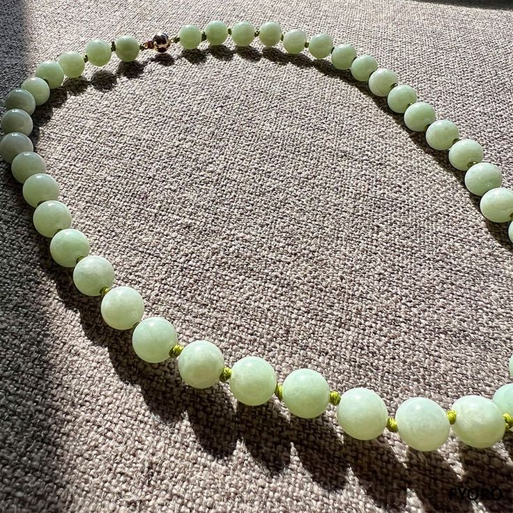 "The \"Imperial Long Jade Necklace\" has 42, 100% pure, Grade-A Jadeite (10mm each) beads; each handpicked and cut by our finest gemologists to create the best, purest necklace. Our long edition shows off each individual bead, showing each ones' similarities and differences. We allow the Jadeite to shine with handcrafted green knots to separate the beads, and seal the story with our signature Gold Clasp. Materials: 0.60g 14K Gold, 42 Grade-A Untreated natural calibrated 10mm Jadeite beads Dimens Elegant Single Strand Round Beads, Elegant Round Jade Beaded Necklaces, Polished Beads For Formal Gems And Cabochons, Luxury Hand-strung Beaded Necklace With Round Beads, Elegant Round Jade Beads, Elegant 8mm Round Beads For Gems And Cabochons, Elegant 8mm Round Beads For Jewelry Making, Luxury Beaded Necklaces With Gemstone Beads, Classic Jade Necklace With Round Beads