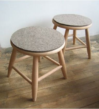 two stools sitting on top of a hard wood floor next to a white wall