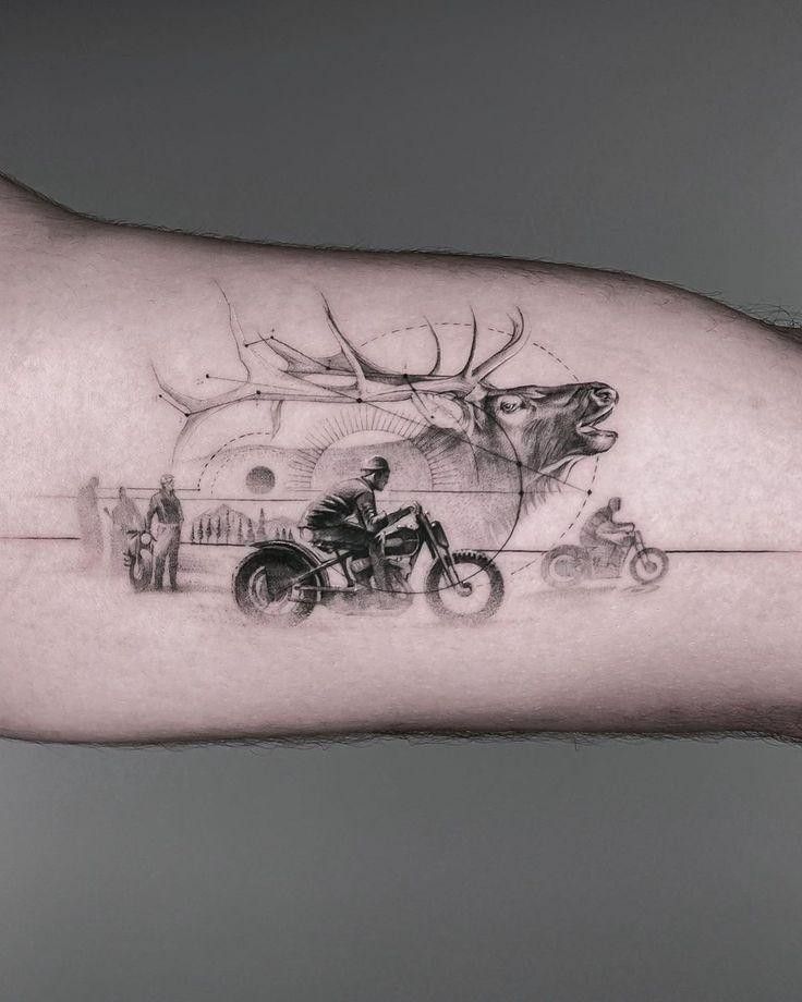 a man's arm with a deer and motorcycle tattoo on it