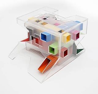 a model of a house made out of multicolored blocks on a white surface