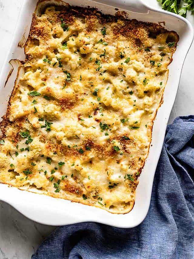 a casserole dish with cheese and herbs on top, ready to be eaten