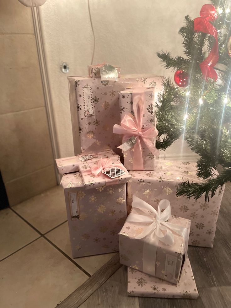 three wrapped presents sitting next to a christmas tree