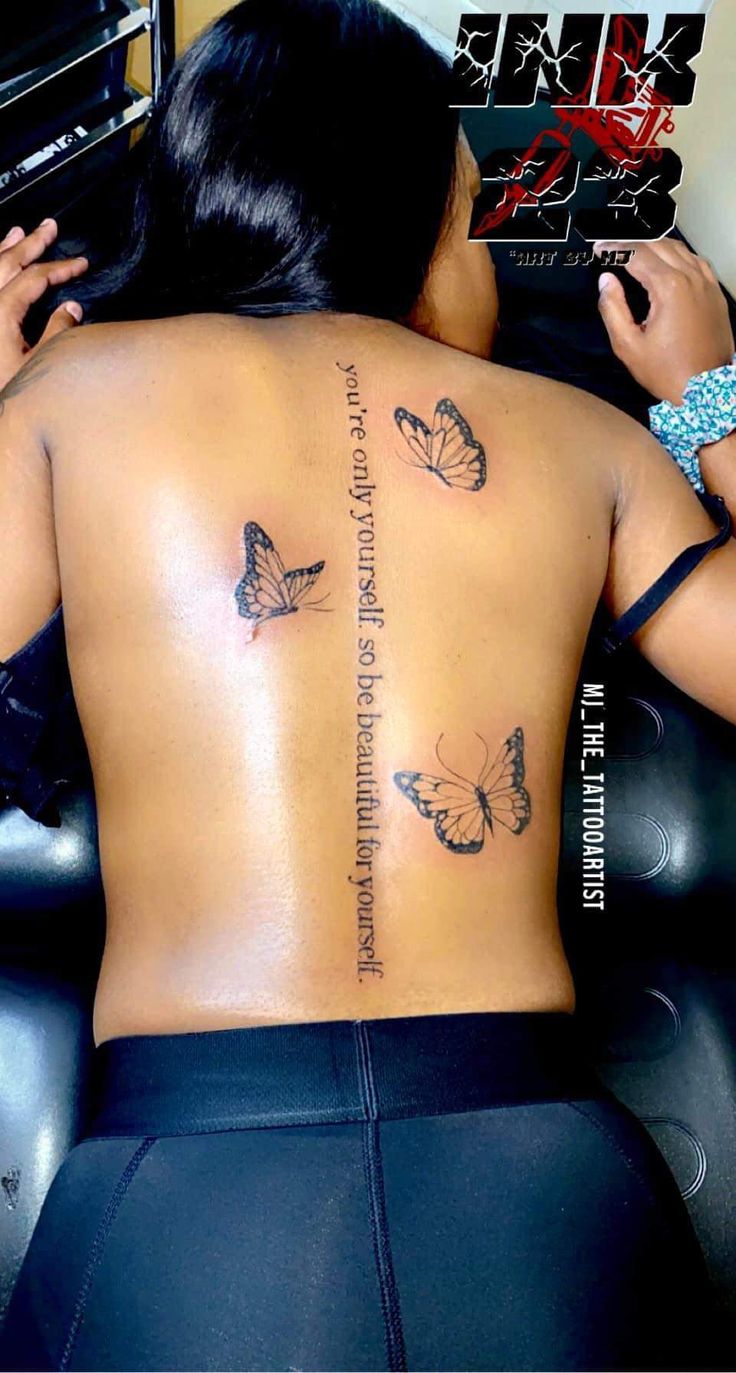 the back of a woman's body with butterfly tattoos on her upper and lower back