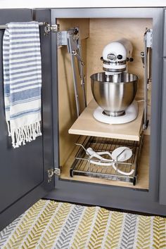 an open kitchen cabinet with a mixer in it