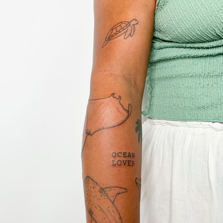 a woman with a tattoo on her arm that says ocean lover and an image of a sea turtle