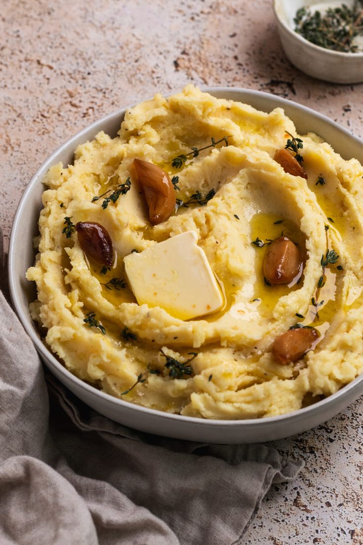 mashed potatoes with olives and parmesan cheese in a bowl on a table