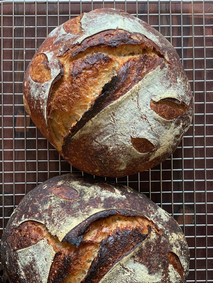 two loaves of bread sitting on top of a cooling rack