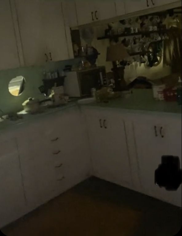 a kitchen with white cabinets and green counter tops in the middle of it at night