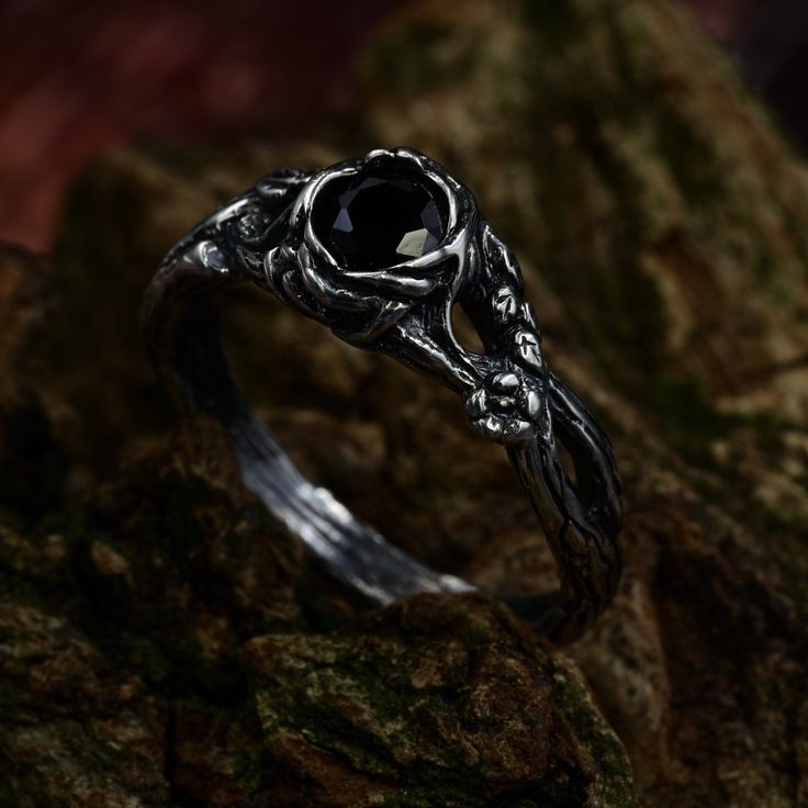 a black diamond ring sitting on top of a rock