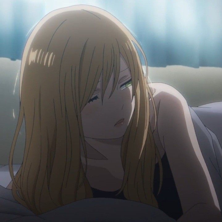 a woman laying on top of a bed with long blonde hair