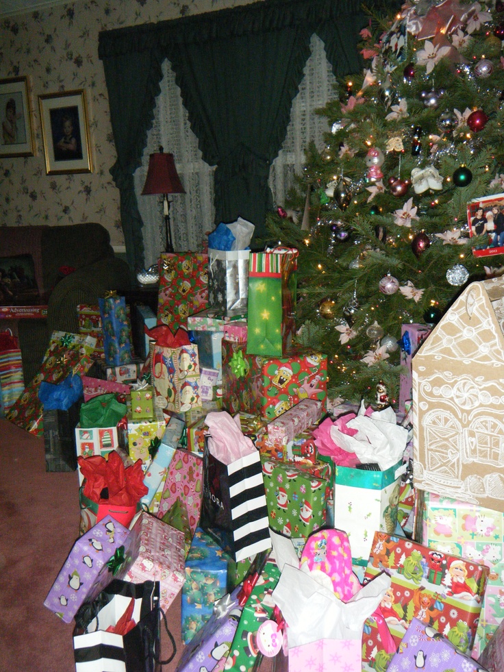 a christmas tree is surrounded by presents under it and wrapped in colorful wrapping paper,