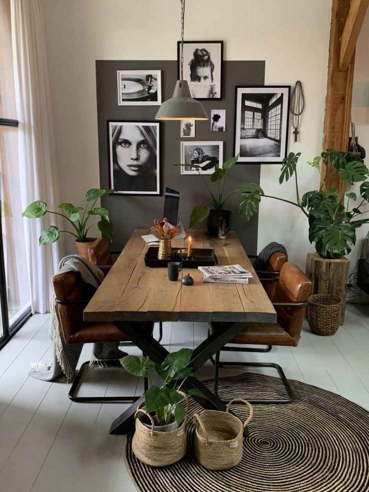 a table with some plants and pictures on the wall