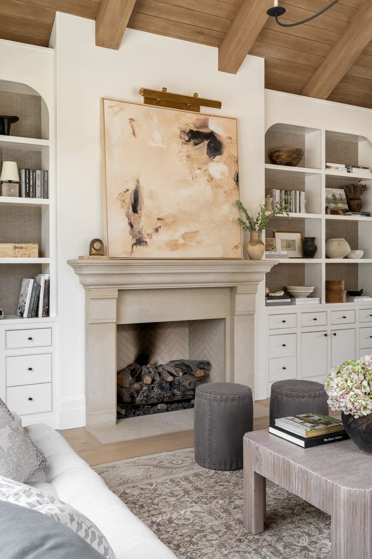 a living room filled with furniture and a fire place in front of a book shelf