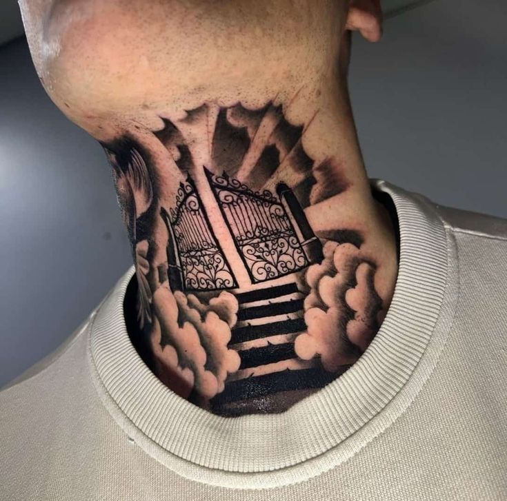 a man's neck with a gate and clouds tattoo on the back of his neck