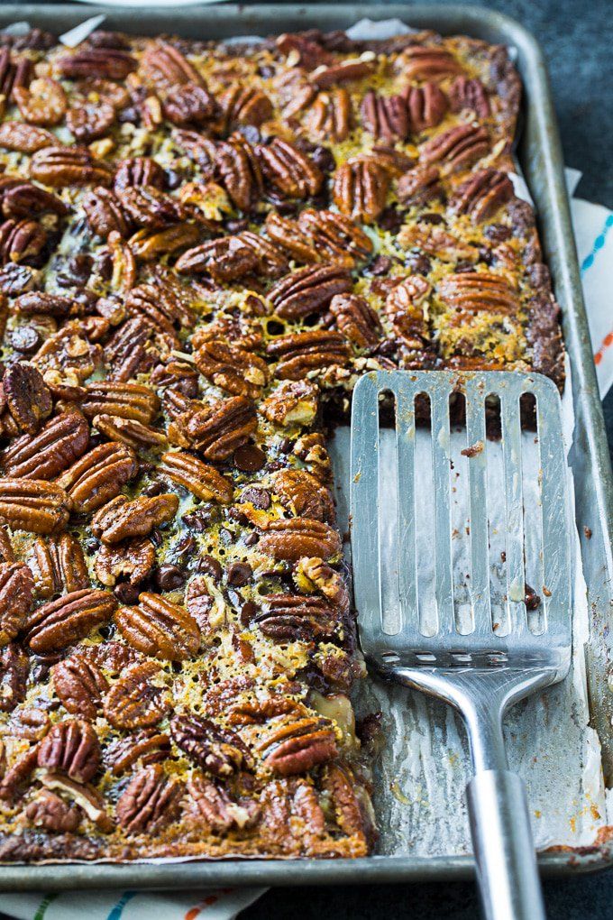 there is a fork that is in the casserole dish with pecans on it