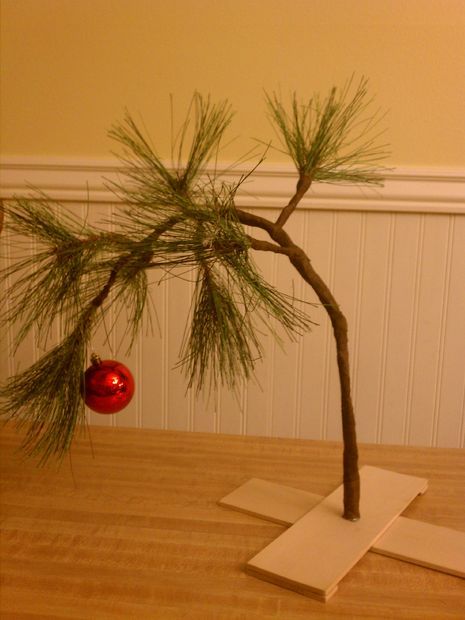 a small pine tree with a red ornament hanging from it