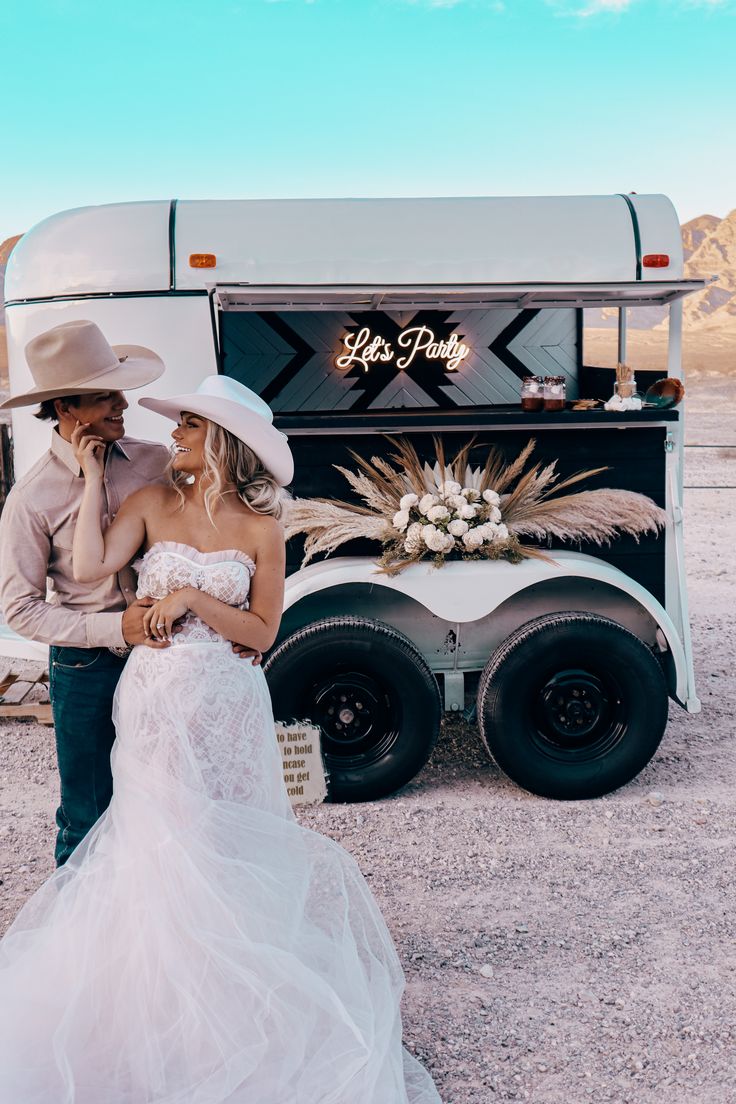 a bride and groom standing in front of a food truck