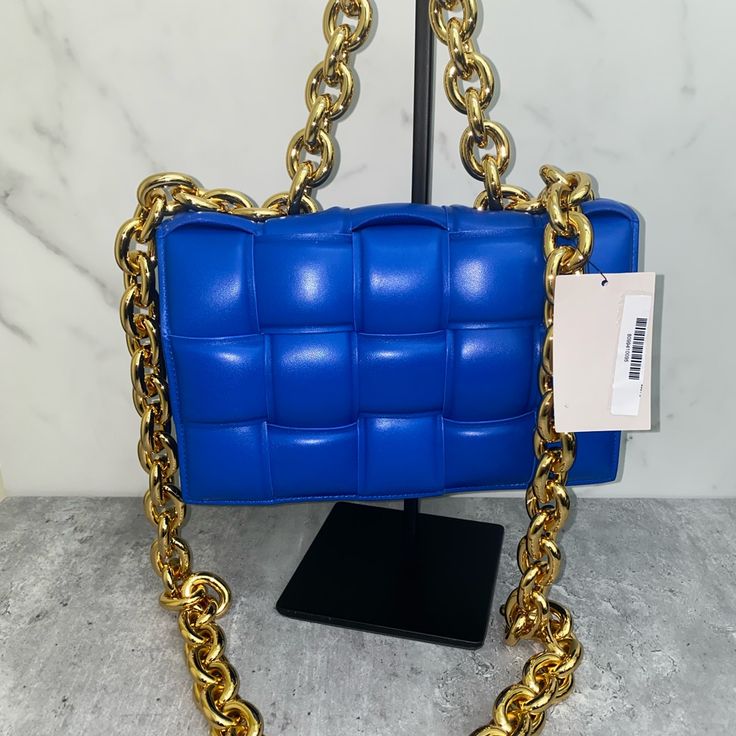 Padded Intrecciato Leather Crossbody Bag One Interior Zipped Pocket Metal Closure Material: 100% Lambskin Lining: Bonded Lambskin Color: Cobalt (Blue) Hardware: Gold Finish Height: 18 Cm | 7.1" Width: 26 Cm | 10.2" Depth: 8 Cm | 3.1" Handle Drop: 13 Cm | 5.1" Strap Drop: 50 Cm | 19.7" Made In: Italy Product Code: 631421vbwz08425 Comes With Dust Bag No Box Never Carried Never Used! Comes From A Smoke Free Pet Free Environment Luxury Blue Square Shoulder Bag, Designer Rectangular Shoulder Bag With Chain Strap, Luxury Blue Bag With Chain Detail, Luxury Blue Bags With Chain Detail, Luxury Blue Bags With Chain, Luxury Blue Chain Bags, Formal Blue Bag With Chain, Blue Evening Bag With Chain Detail, Luxury Rectangular Bag With Gold Chain