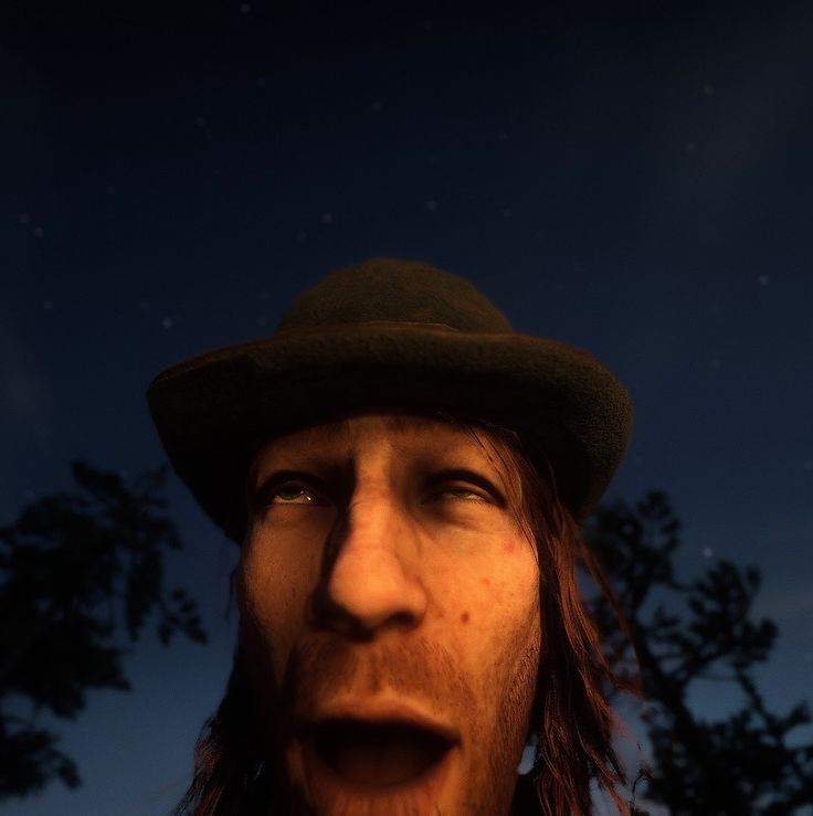 a man with long hair wearing a hat and looking up at the stars in the sky