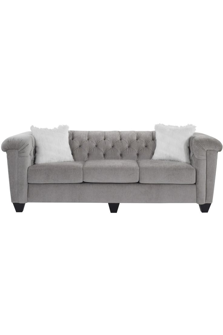 a gray couch with white pillows on it