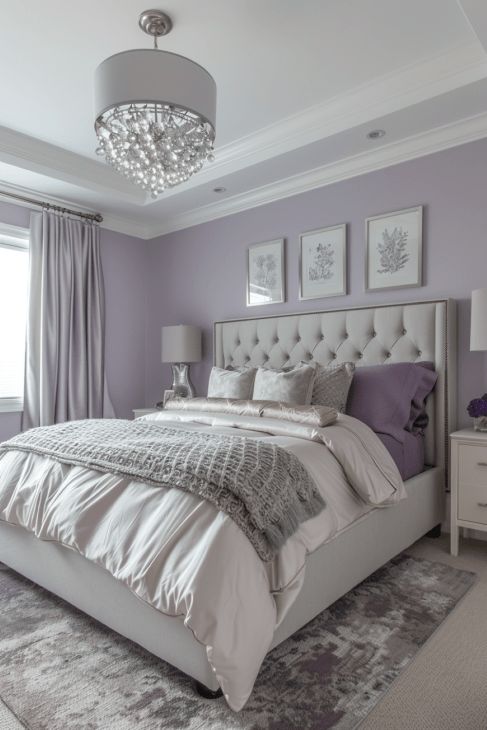 a bedroom with purple walls and white bedding, chandelier above the headboard