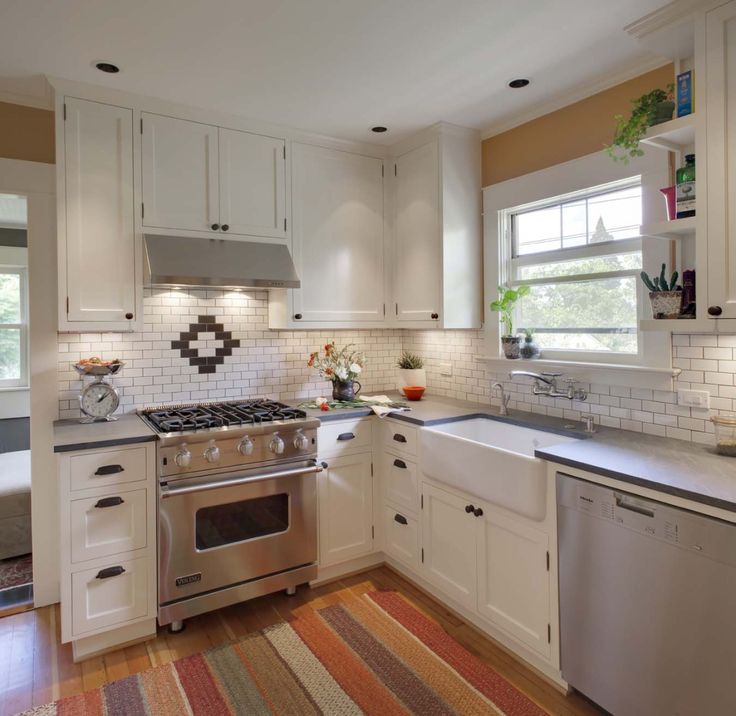 a kitchen with an oven, dishwasher, sink and rug on the floor