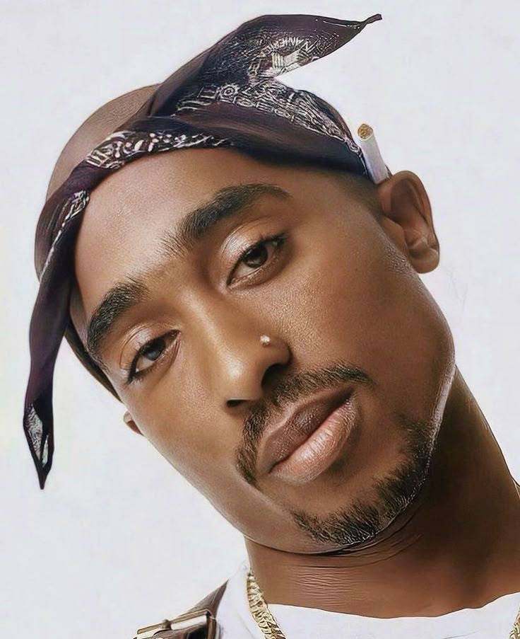 a close up of a person with a bandana on his head and wearing a necklace