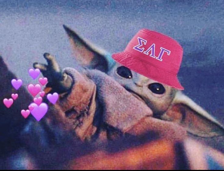 a baby yoda wearing a red hat with hearts