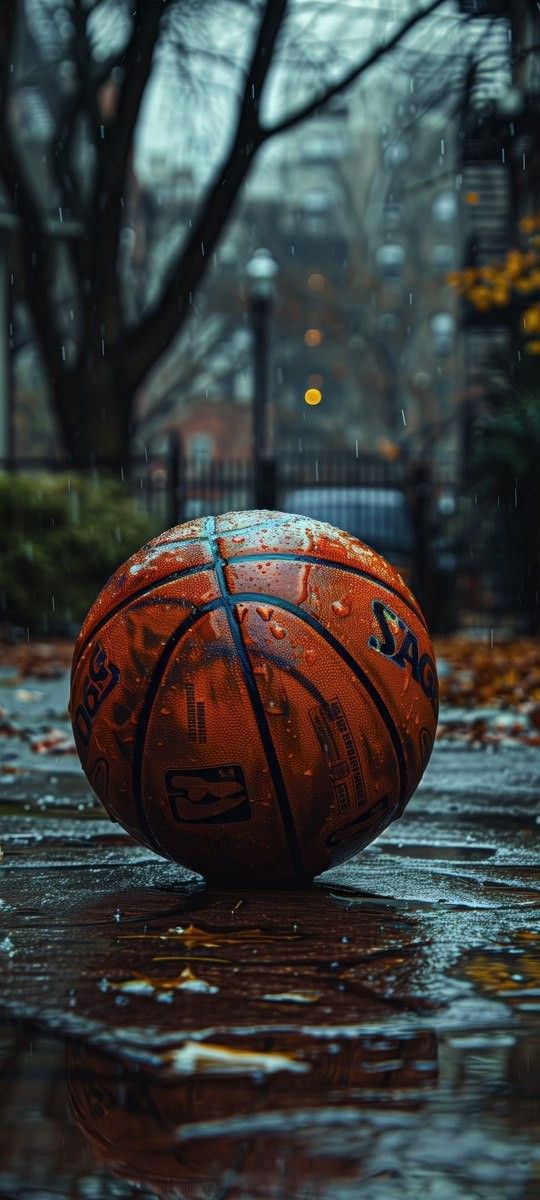 an orange basketball sitting on top of a wet ground