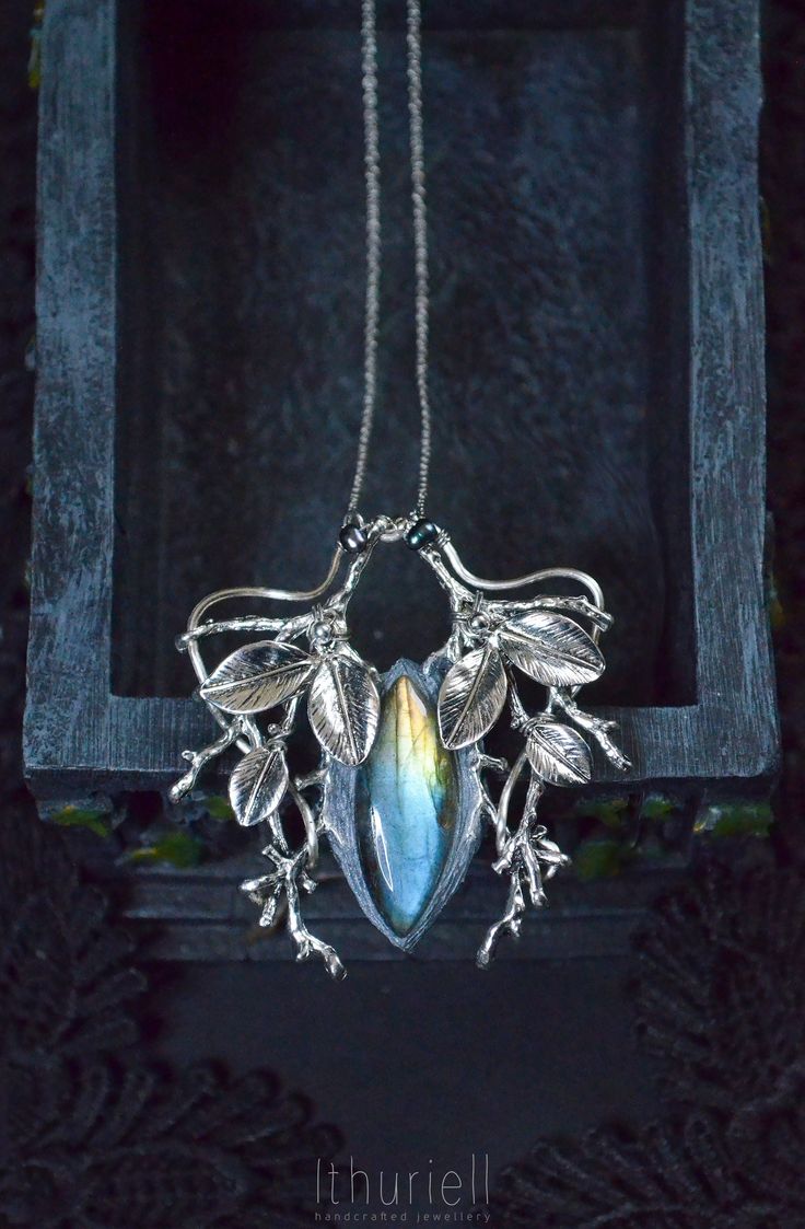 An exquisite necklace of yellow-blue labradorite reminding of an enchanted sword. Set into silvery branches and leaves, it would work great both for layering and as a centerpiece of your style.  A beautiful adornment with an air of grace and romance. Blue labradorite, metal (Zinc-based alloy), polymerclay. Ethereal and magical. Dimensions:  2.5 x 2.25 inches / 6.3 x 5.3 cm Overall length is 46 cm / 18 inches + 2.5 inches for adjusting Comes in a cardboard jewelry box that can be used as a gift wrap (or just for storing your precious trinket ;) If you like what you see, you may also like to check my Facebook page: https://www.facebook.com/ithuriell or Instagram: https://www.instagram.com/ithuriell.crafts/ (there are sneak peeks, faerie tales and, of course, more about faerie jewellery!) Silver Labradorite Nature-inspired Jewelry, Silver Labradorite Necklace Nature-inspired, Nature-inspired Silver Labradorite Jewelry, Silver Labradorite Necklace, Nature-inspired, Nature-inspired Silver Labradorite Necklace, Silver Labradorite Necklace With Nature-inspired Style, Magical Labradorite Jewelry Gift, Handmade Magical Labradorite Jewelry, Faery Jewelry