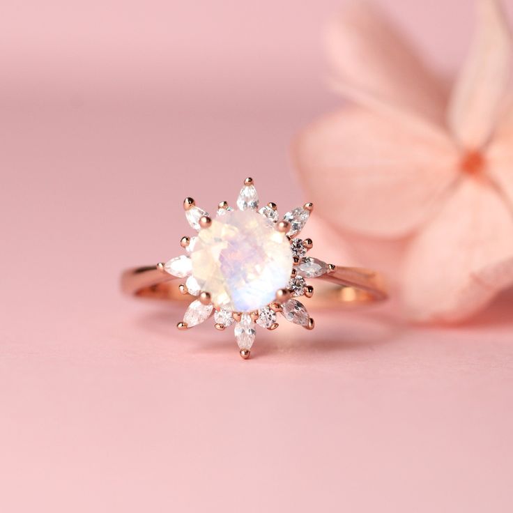 This elegant moonstone ring has a big center moonstone stone in prong setting, stone size is about 6-7 mm, and the cubic zirconia pave surrounding as halo, made of solid 925 sterling silver with rose gold plate to give it a luxury, romantic look. This ring is a perfect anniversary ring, party ring or gift for your love one. Ring size: 5,6,7,8,9 US Shipping Policy: Order will be shipped within 1-3 business days. First class mail will take 7-14 days to arrive for U.S. orders. International shippin Celestial Halo Setting Promise Ring Jewelry, Opal Ring With Cubic Zirconia And Halo Setting, Rose Gold Moonstone Halo Promise Ring, Celestial Rings With Halo Setting And Round Cut, Moonstone Halo Setting Promise Ring, Moonstone Rings With Halo Setting For Promise, Cubic Zirconia Crystal Ring With Halo Setting For Proposal, Elegant Wedding Moonstone Ring With Halo Setting, Rose Gold Halo Moonstone Ring For Wedding