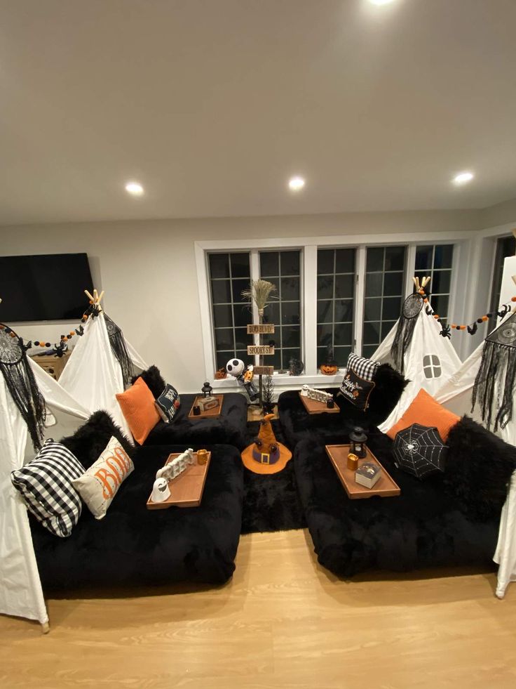 a living room filled with black couches and pillows