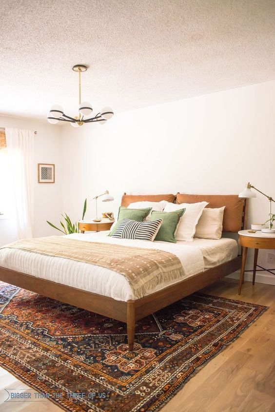 a large bed sitting on top of a wooden floor next to a window in a bedroom