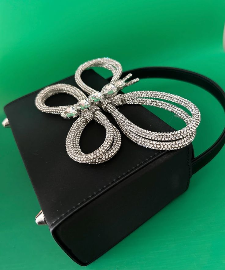 A glamor bag that incorporates elegance and glamour to add subtle sparkle to any outfit. The black satin finish is the perfect summer shade to complement an evening seaside cocktail and its petite size makes it an ideal companion for any occasion. Perfectly fits in your phone and other items. Dimensions: 16cm x 12cm x 7cm Estimated Delivery: 3-5 Days Elegant Summer Clutch Bag, Elegant Summer Bags, Chic Party Clutch For Mobile Phones, Mobile Phone Bag For Summer Parties, Summer Party Mobile Phone Bag, Silver Pouch Evening Bag, Summer Party Evening Bag With Pearl Handle, Summer Evening Mobile Phone Bag, Silver Evening Mobile Phone Bag