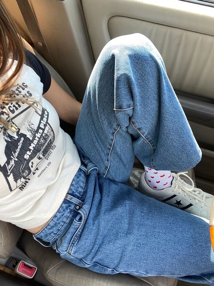 a woman sitting in the back seat of a car with her feet up on the floor