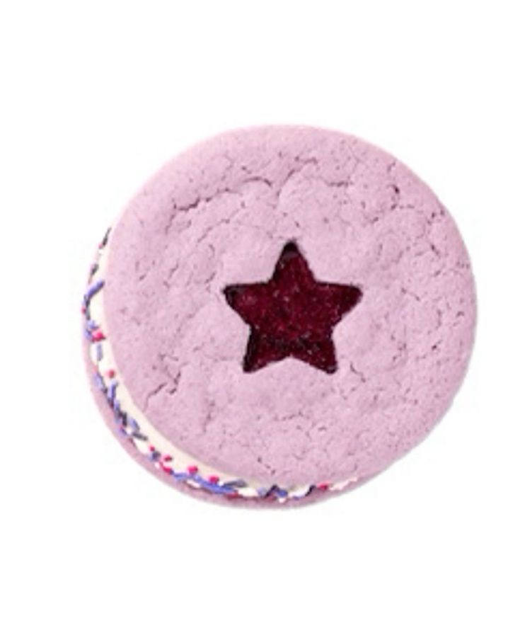 a pink round cake with a red star on the top and sprinkles around it