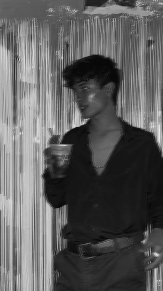 a black and white photo of a man holding a cup