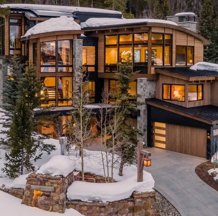 a large house with lots of windows and snow on the ground