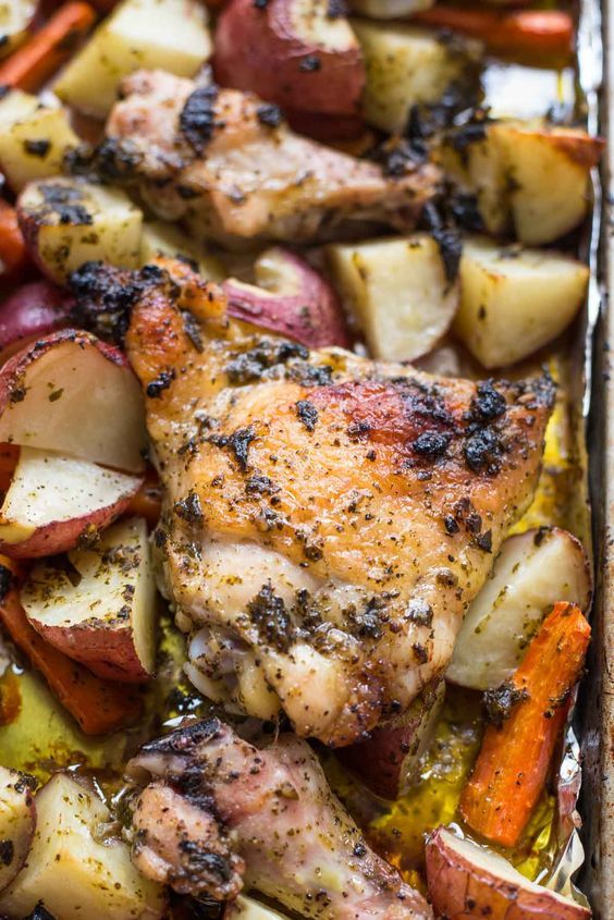 chicken, potatoes and carrots on a baking sheet