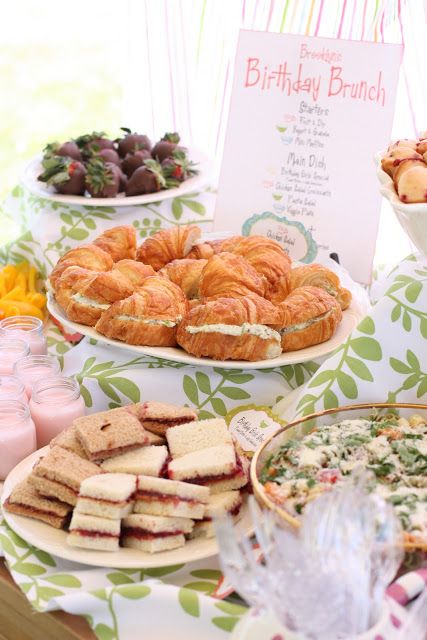 a table topped with lots of food and desserts next to a sign that says birthday brunch