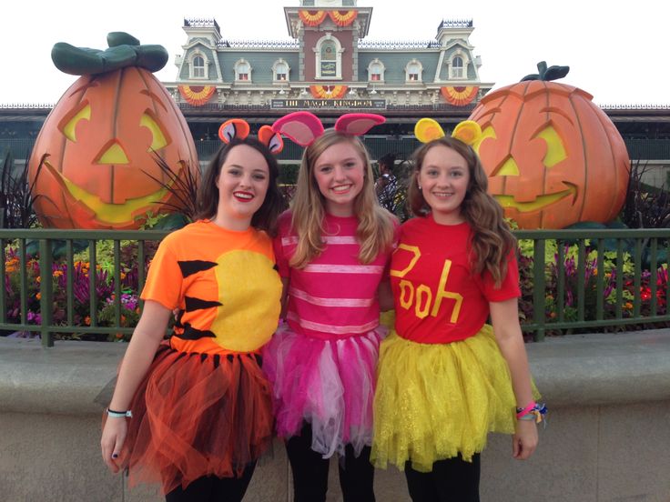 three girls dressed up in halloween costumes standing next to each other with pumpkins behind them