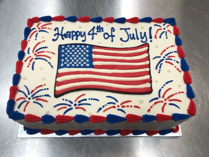 a fourth of july cake with an american flag and fireworks on the side, sitting on a silver surface