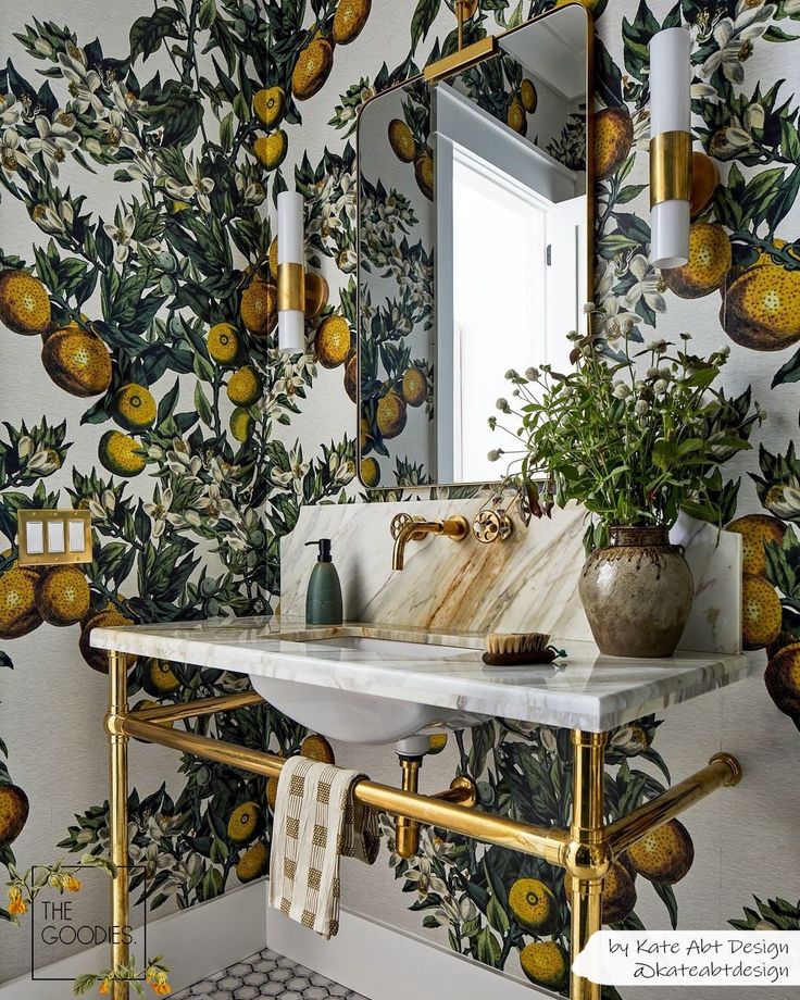 a bathroom with a sink, mirror and wallpaper that has lemons on it