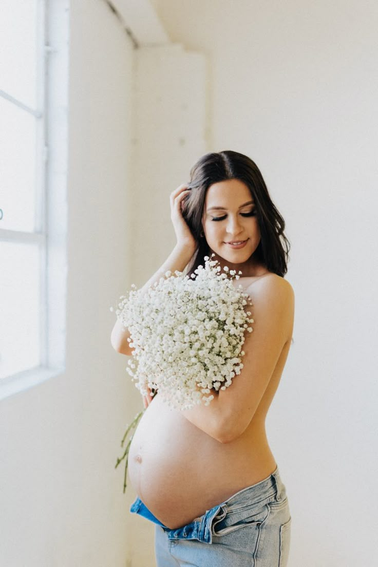 a pregnant woman holding flowers in her belly