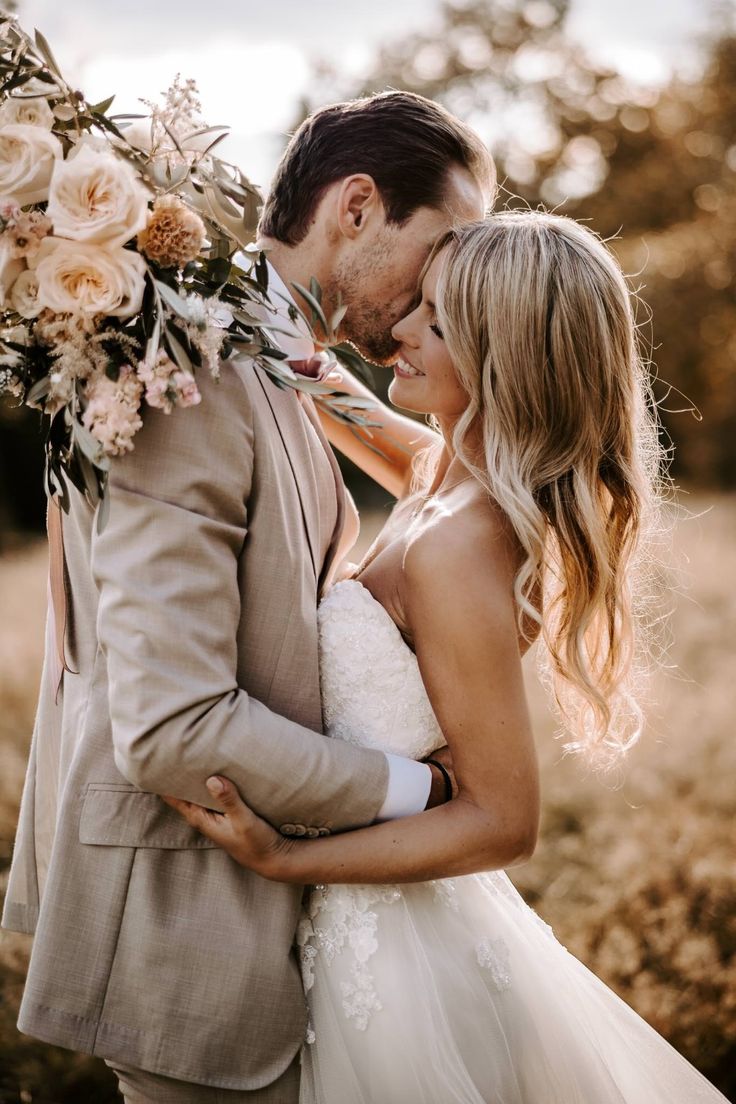 a bride and groom embracing each other with flowers in their hair