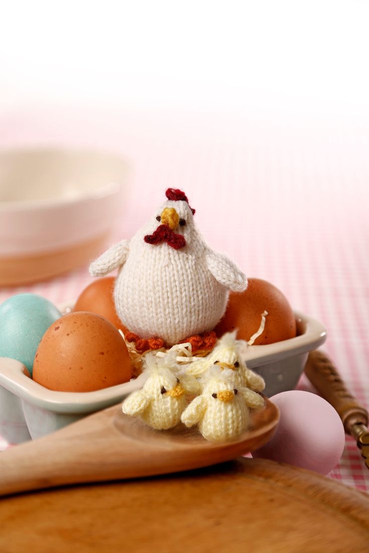 an egg with a chicken on it sitting in a bowl next to eggs and shells