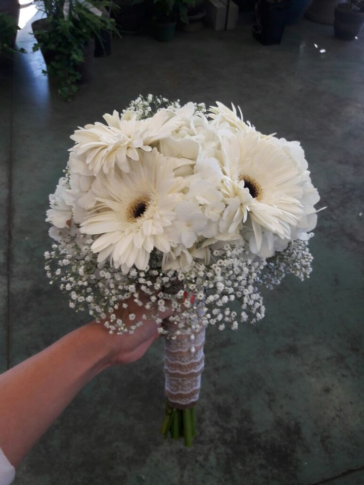 a bouquet of white flowers being held by someone