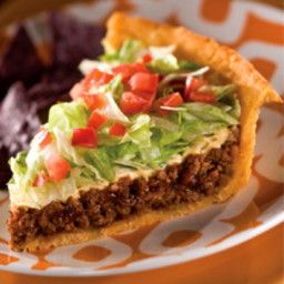 a piece of pie with lettuce and tomatoes on it sitting on a plate