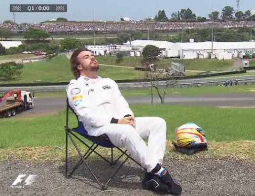 a man sitting in a chair next to a soccer ball on top of a field